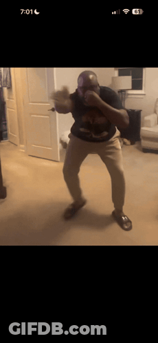A Man Is Boxing In A Living Room With The Time 7:01 GIF