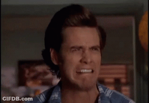 A Man Is Brushing His Teeth In Front Of A Bathroom Mirror . GIF