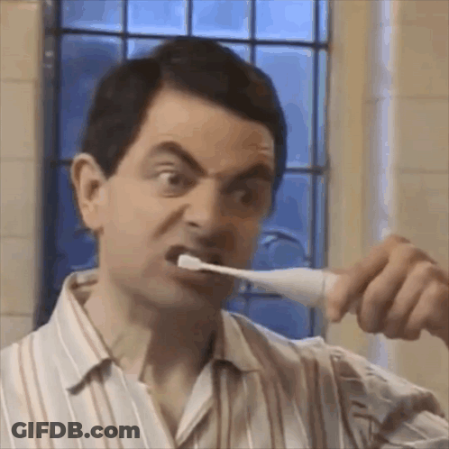 A Man Is Brushing His Teeth With A Toothbrush In A Bathroom . GIF