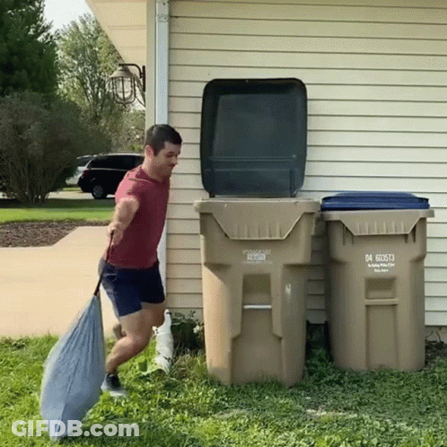A Man Is Carrying A Bag In Front Of A Garbage Can That Says 04 60573 GIF
