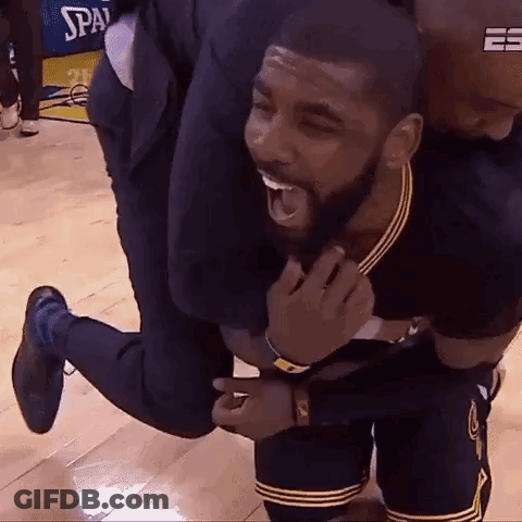 A Man Is Carrying A Basketball Player On His Back On A Wooden Floor . GIF