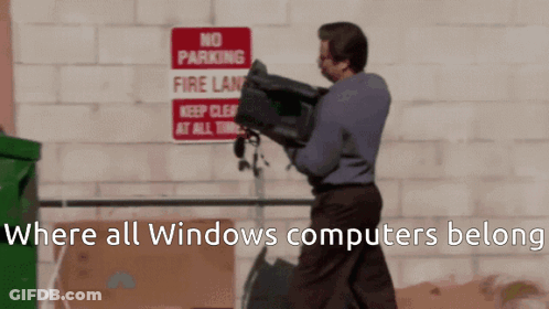 A Man Is Carrying A Computer In Front Of A Sign That Says No Parking Fire Lane GIF
