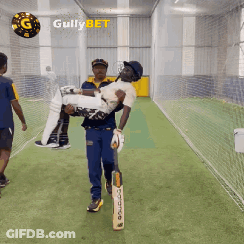 A Man Is Carrying A Cricket Player In His Arms With Gullybet Written On The Bottom GIF
