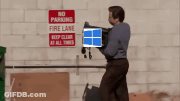 A Man Is Carrying A Laptop In Front Of A No Parking Fire Lane Sign GIF