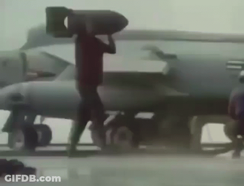 A Man Is Carrying A Large Bomb On His Head GIF