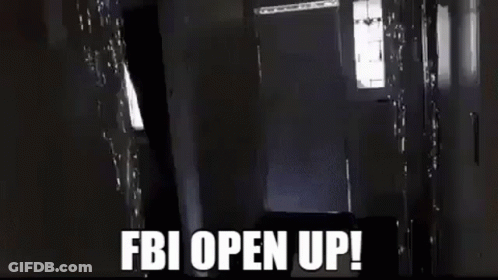 A Man Is Carrying A Large Box In A Hallway And The Words `` Fbi Open Up '' Are Written On The Screen . GIF