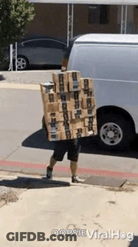 A Man Is Carrying A Stack Of Boxes On His Back And Says Oopsie Viralhog On The Bottom GIF
