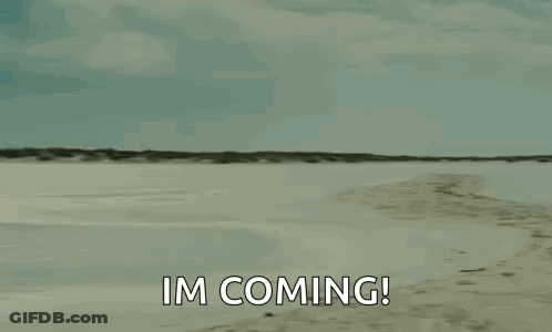 A Man Is Carrying A Woman On His Shoulders On A Beach And Saying `` Im Coming '' . GIF