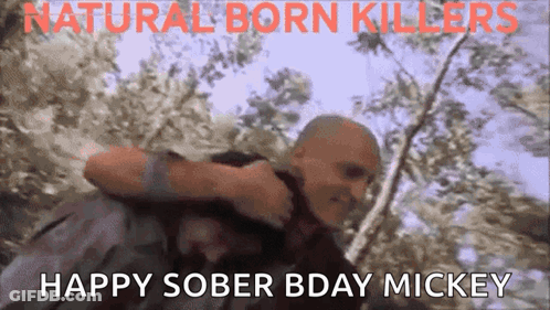 A Man Is Carrying Another Man In His Arms With The Words " Happy Sober Bday Mickey " On The Bottom GIF