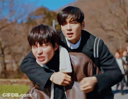 A Man Is Carrying Another Man On His Back And They Are Making Funny Faces . GIF