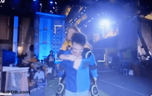 A Man Is Carrying Another Man On His Shoulders In A Dark Room . GIF