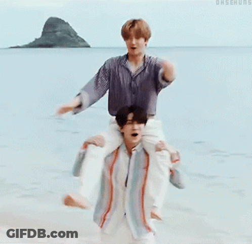 A Man Is Carrying Another Man On His Shoulders In The Water GIF