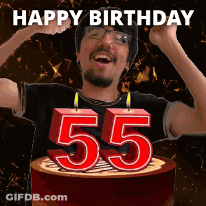 A Man Is Celebrating His 55Th Birthday By Blowing Out Candles On A Cake GIF