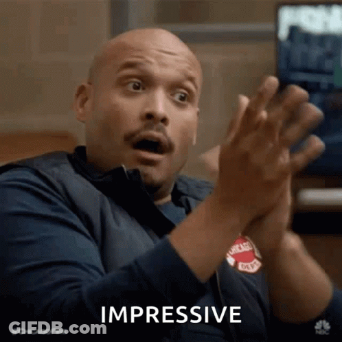 A Man Is Clapping His Hands And Making A Surprised Face While Sitting In Front Of A Television . GIF