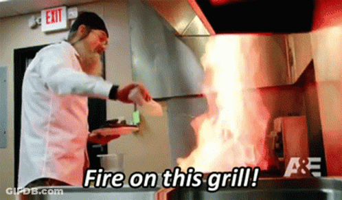 A Man Is Cooking Food In A Kitchen And Says Fire On This Grill GIF