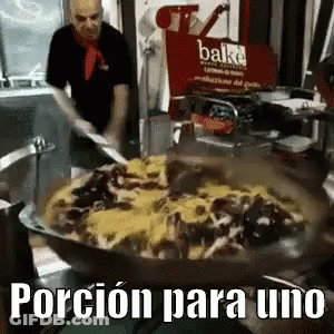 A Man Is Cooking Food In A Pan With The Words Porcion Para Uno In The Corner GIF