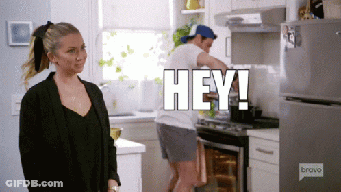 A Man Is Cooking In A Kitchen And A Woman Is Standing In Front Of Him With The Words Hey Written Above Him GIF