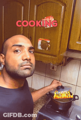 A Man Is Cooking In Front Of A Cabinet That Says Cooking On It GIF