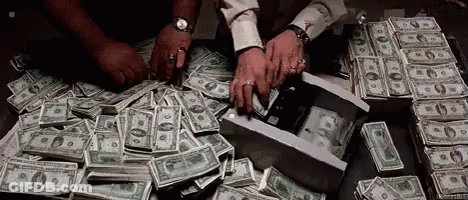 A Man Is Counting Money On A Table . GIF