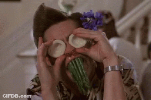 A Man Is Covering His Eyes With Cucumbers And Asparagus . GIF