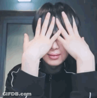 A Man Is Covering His Eyes With His Hands . GIF