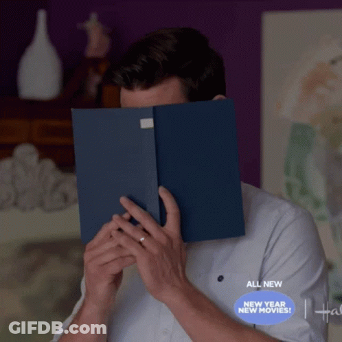 A Man Is Covering His Face With A Book And The Words All New New Year New Movies Are Below Him GIF