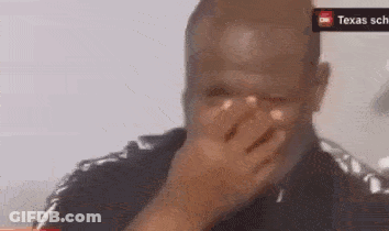 A Man Is Covering His Face With His Hand In Front Of A Sign That Says Texas GIF