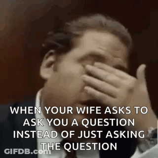 A Man Is Covering His Face With His Hand While Talking To His Wife . GIF