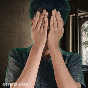 A Man Is Covering His Face With His Hands GIF