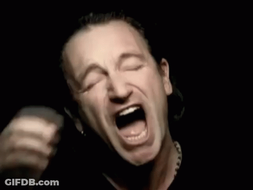 A Man Is Covering His Face With His Hands While Screaming In The Dark . GIF