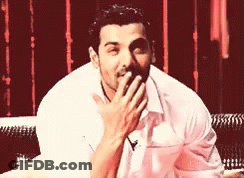 A Man Is Covering His Mouth With His Hand GIF