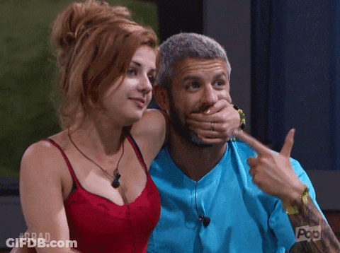 A Man Is Covering His Mouth With His Hand And A Woman Is Pointing At Him GIF