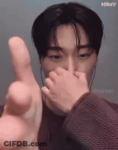 A Man Is Covering His Nose With His Hand And Giving The Middle Finger . GIF