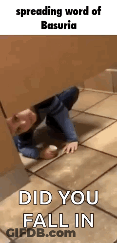 A Man Is Crawling On The Floor In A Bathroom Stall While Holding A Cup . GIF