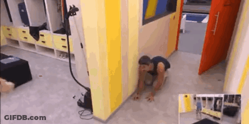 A Man Is Crawling On The Floor In A Room With Yellow And Blue Walls . GIF