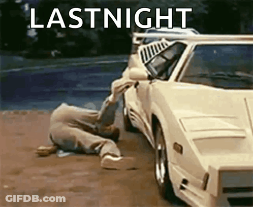 A Man Is Crawling On The Ground Next To A White Car With The Words Lastnight Written On It . GIF
