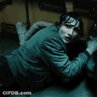 A Man Is Crawling Under A Sink With The Words " Are You By " Glowing On His Shirt GIF