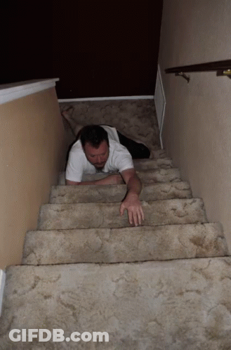 A Man Is Crawling Up A Set Of Stairs With His Legs Crossed GIF
