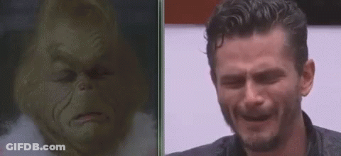 A Man Is Crying Next To A Picture Of Grinch . GIF