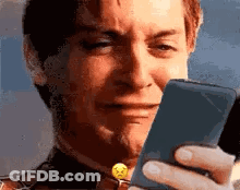 A Man Is Crying While Looking At His Phone . GIF