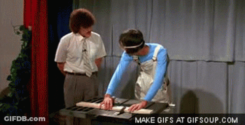 A Man Is Cutting A Piece Of Wood On A Table Saw While Another Man Looks On GIF
