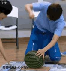 A Man Is Cutting A Watermelon With A Knife . GIF