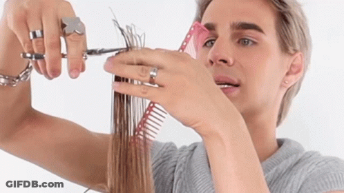 A Man Is Cutting His Hair With A Pair Of Scissors And A Comb GIF