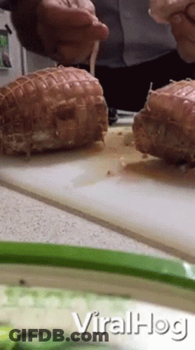 A Man Is Cutting Meat On A Cutting Board With The Words Viralhog Written On The Bottom GIF