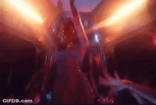 A Man Is Dancing In A Club With His Arms In The Air And A Crowd Behind Him . GIF