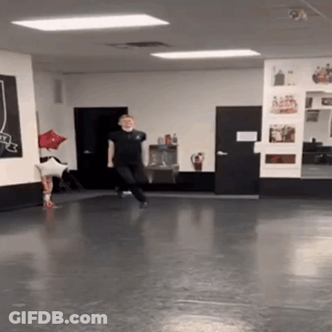 A Man Is Dancing In A Dance Studio With A Red Balloon In The Background . GIF