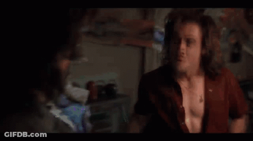 A Man Is Dancing In A Dark Room With His Arms Outstretched . GIF