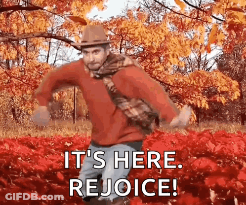 A Man Is Dancing In A Field Of Red Leaves With The Words `` It 'S Here Rejoice '' . GIF