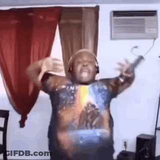 A Man Is Dancing In A Living Room Wearing Headphones And A Star Wars Shirt . GIF