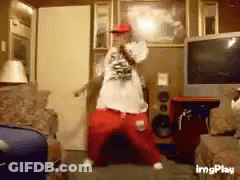 A Man Is Dancing In A Living Room With A Microphone In His Hand GIF